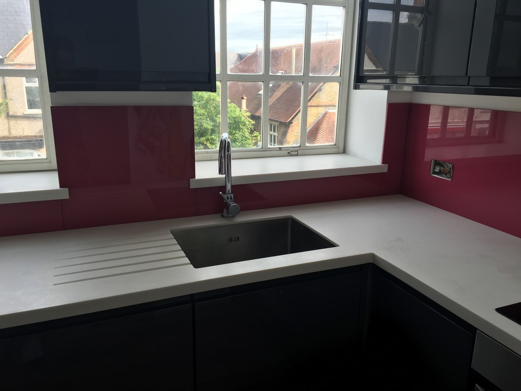 Deep plum coloured glass splashback in modern Chelsea kitchen